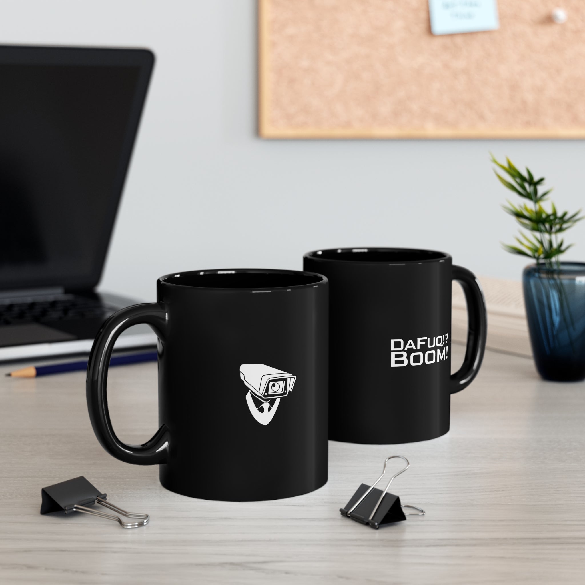 2 Glossy black mugs with DaFuq!?Boom! logo and camera icons on a wooden desk with laptop and clips and plant