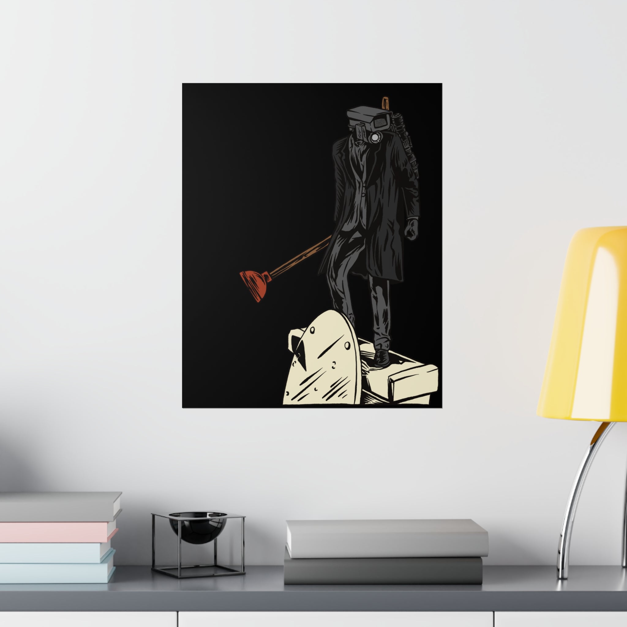 Plungerman art on black matte poster hung over credenza with lamp and books